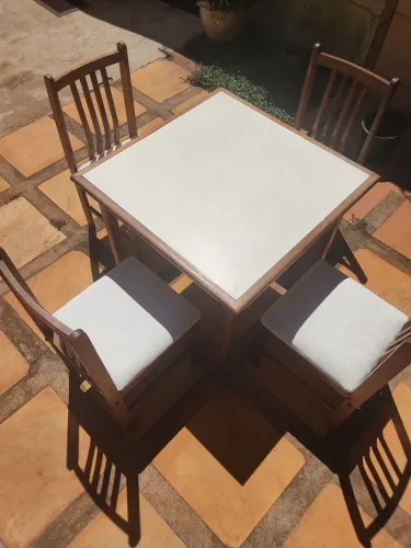 Mesa de madeira com 4 cadeiras, estofado branco.