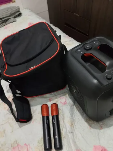 Caixa de som JBL bem conservada sem marcas de uso,acompanha dois microfones e a capa.