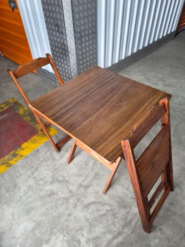 Mesa em madeira Tarimatã com duas cadeiras todos dobráveis. Ideal para varandas pequenas