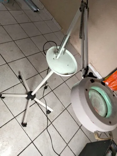 luminária com lupa articulada e tripé de rodinhas.