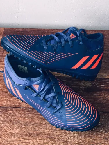chuteira society Adidas Predator Edge.4 TF na cor azul com detalhes em laranja.