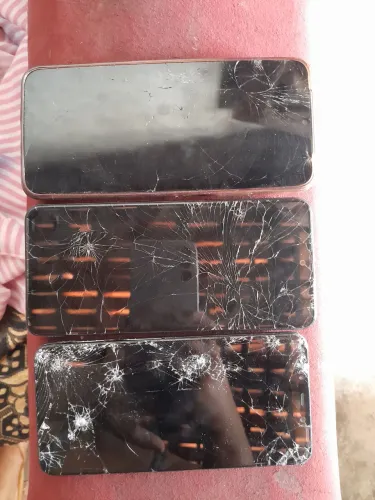 Celular com tela quebrada.