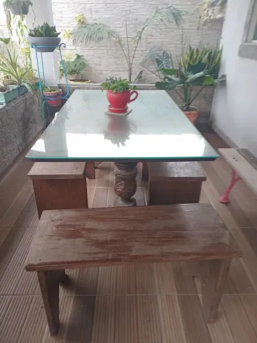 Mesa de madeira com vidro.sobre posto com bancos de madeira