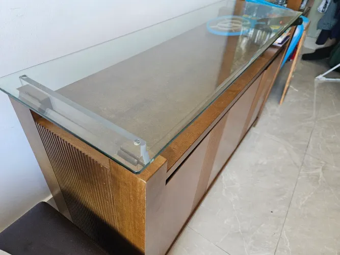 Buffet em madeira, com 3 portas e tampo de vidro.