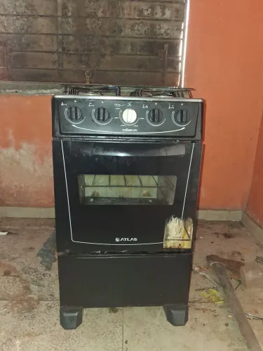 Um fogão 4 bocas seme novo preto no ponto de uso