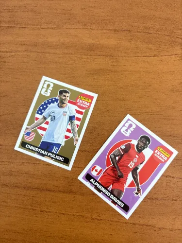 Figurinha Legend Ouro/(Bordô/Roxo) Panini - Christian Pulisic e Alphonso Davies