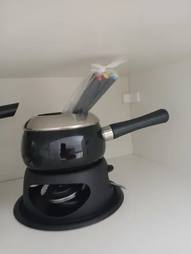 Aparelho de fondue está completo, com a panela, suporte, queimador e os 6 a 8