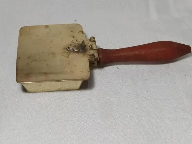 Antigo cata migalhas decada de 60 em metal dourado cabo madeira nobre