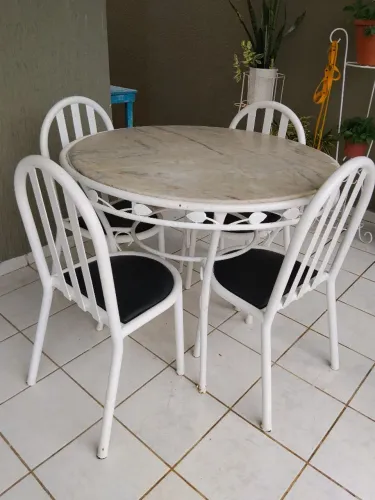 Mesa de mármore com quatro cadeiras de ferro turbular