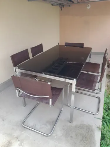 Mesa aço inox com tampo de vidro e cadeiras em couro