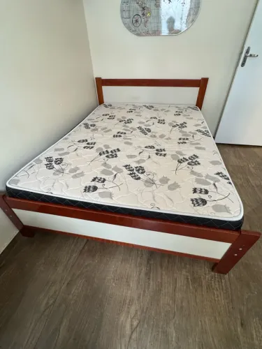 Cama com colchão e mesa de cabeceira