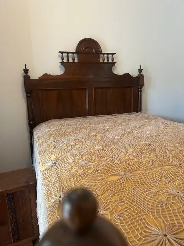 Cama de madeira maciça com detalhes entalhados e torneados 
