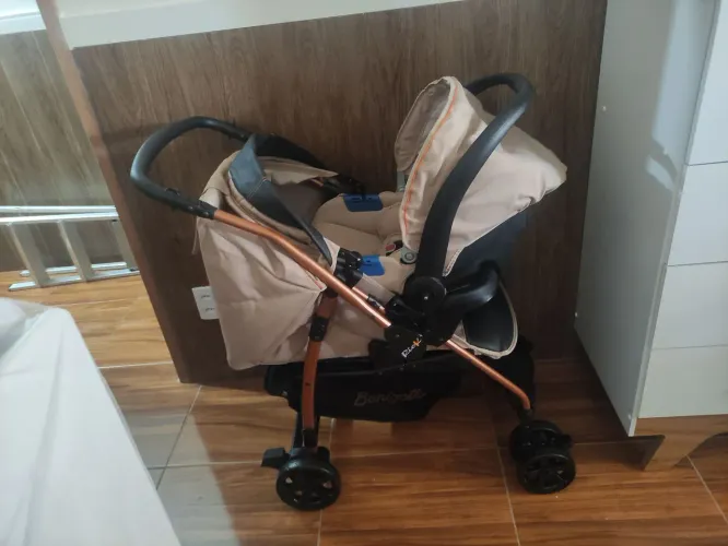 Carrinho de bebê com bebê conforto e base