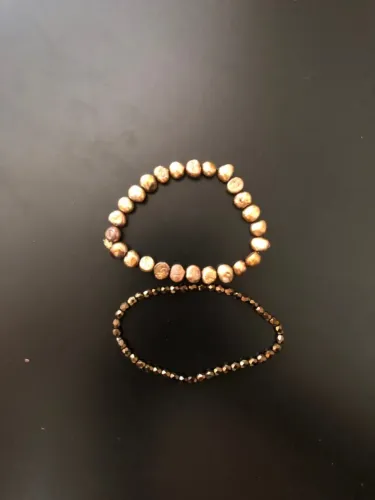Duas pulseiras douradas, duas texturas. Rústica e brilhante no mesmo pulso.