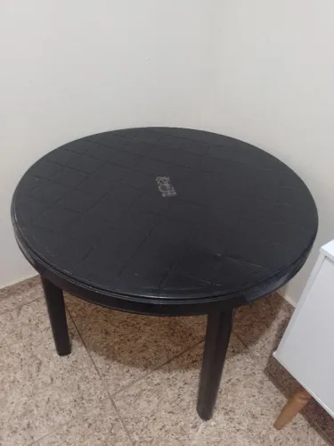 Mesa redonda preta com orifício.