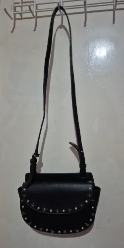 Bolsa transversal preta com detalhes de estrelas prata