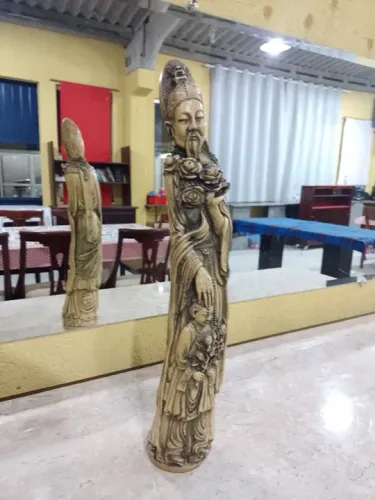 Estatua grande de um Chines protegendo uma criança lindíssima leia