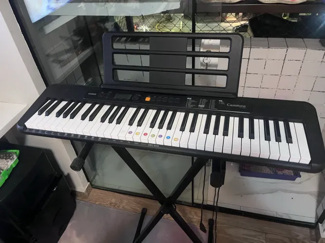 Pelas fotos, é um Casio Casiotone CT-S200, de 61 teclas, com suporte.