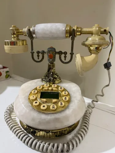 telefone retrô de estilo europeu com detalhes em mármore sintético e dourado. 
