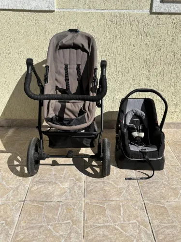 Carrinho de bebê com bebê conforto.