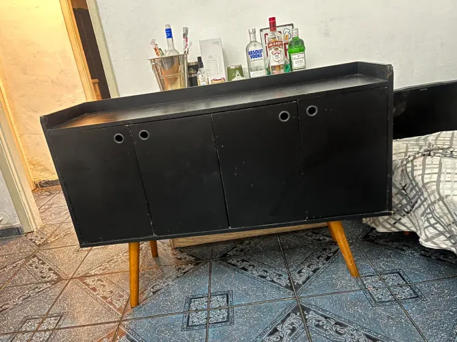 Buffet preto com pés de madeira