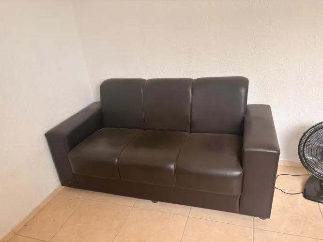 Vendo um sofá de 3 lugares, em courino, em excelente estado de conservação, na cor preta.
