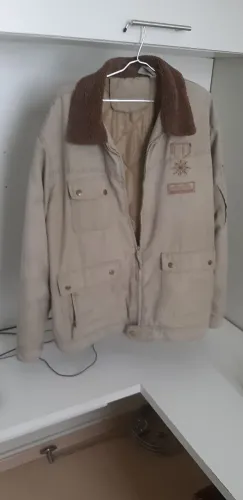 Jaqueta cor bege, fabricada nos Emirados Árabes Unidos.