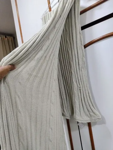 Peça de roupa em tricô na cor bege com textura canelada e detalhes em trança 