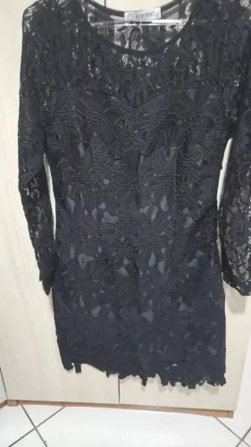 Vestido preto rendado, manda longa somente renda, comprimento médio.