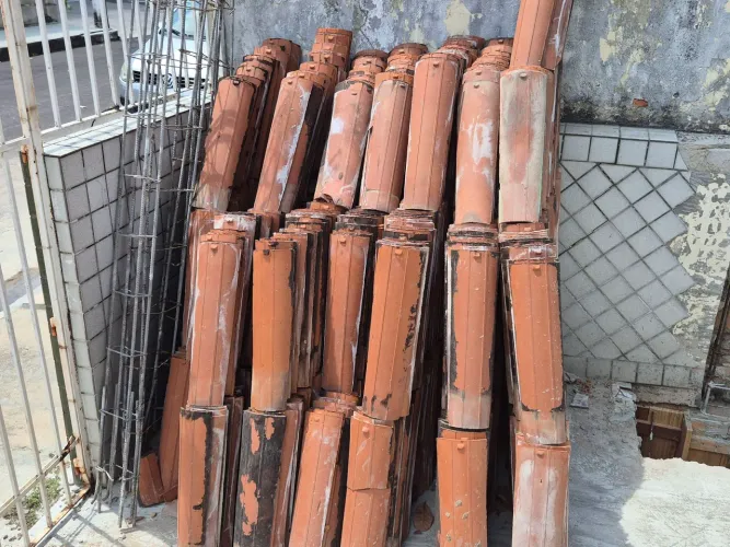 Janelas, telhas, grades e portão de ferro.