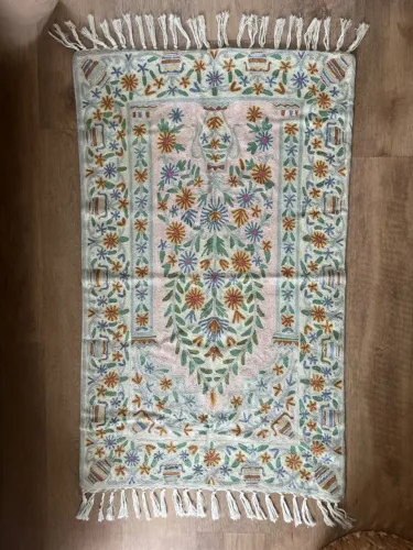 Tapete têxtil com bordados coloridos