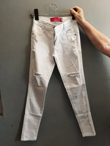 Calça jeans branca com rasgos frontais.