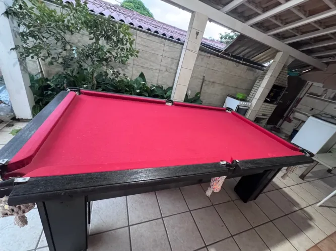Mesa de sinuca com tacos e bolas