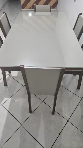 Mesa com tampo de vidro e 6 cadeiras.