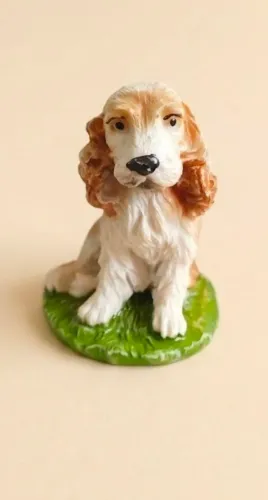 Estatueta decorativa em resina, representando um cão da raça Cocker Spaniel Inglês sentado