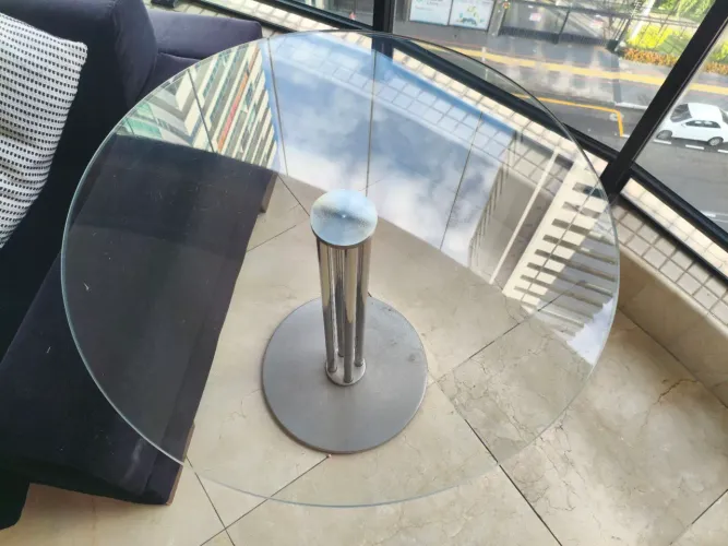 mesa lateral de vidro com base cromada.