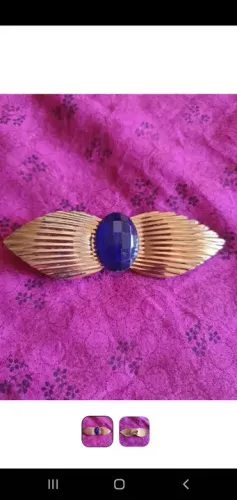 Broche dourado com pedra azul