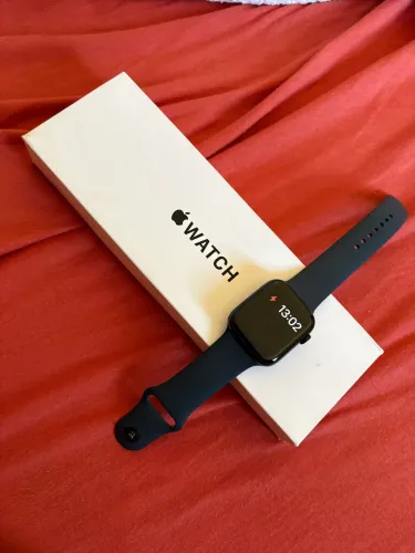 Apple Watch na cor preta, acompanhado de caixa, pulseira e carregador magnético.