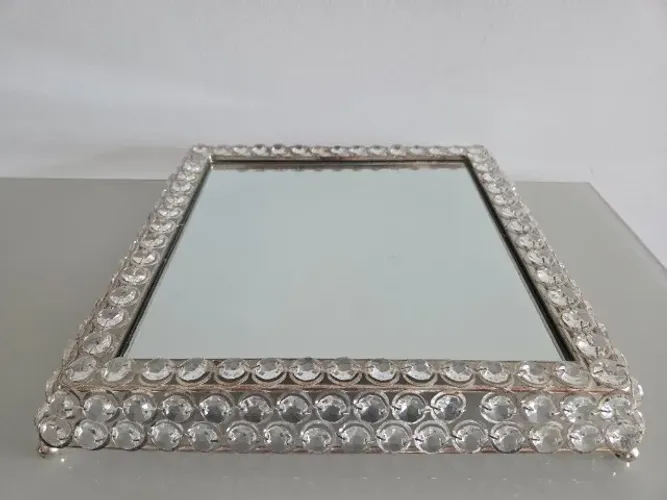 Bandeja espelhada é um item decorativo elegante, com bordas adornadas por cristais