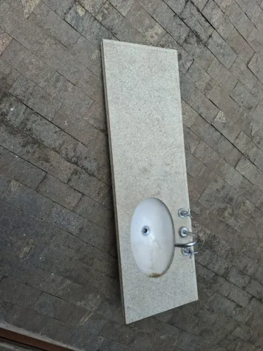 Pia de banheiro com cuba e torneiras.