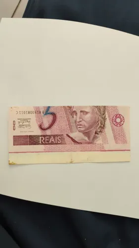 Cédula de R$ 5,00 verdadeira com erro de corte.