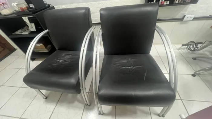 Poltrona de couro com braços em alumínio.