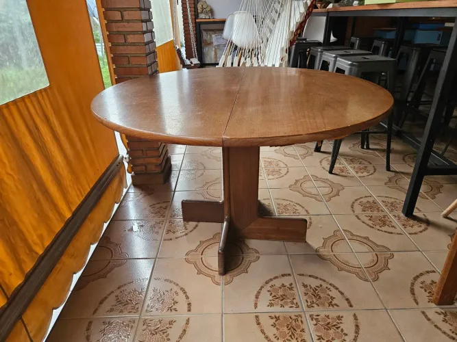 Mesa redonda elástica de madeira, pés maciços e tampo folheado de cerejeira.