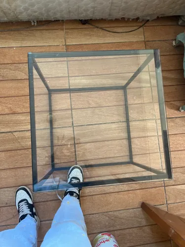 Mesa baixa com tampa de vidro quadrada. Suporte preto