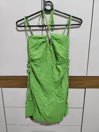 Vestido verde de festa com amarração no pescoço e detalhes de amarrar dos lados