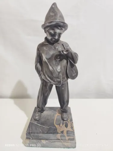 Uma escultura em Petit bronze, menino c/ bandolim 