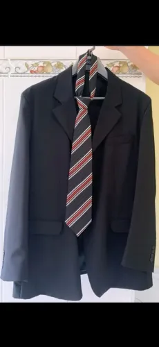 Terno/blazer preto com gravata listrada.