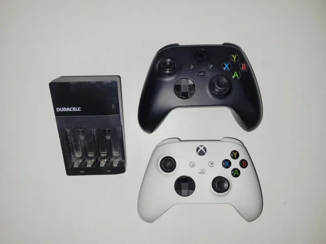 Dois controles Xbox series S e carregador de pilhas Duracell.