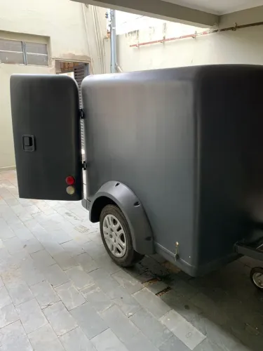 Carretinha fechada com moveis e compressor.