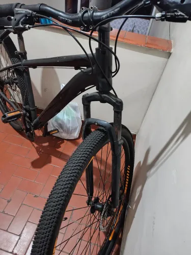 Bicicleta MTB preta com detalhes laranja ? Shimano e freio a disco